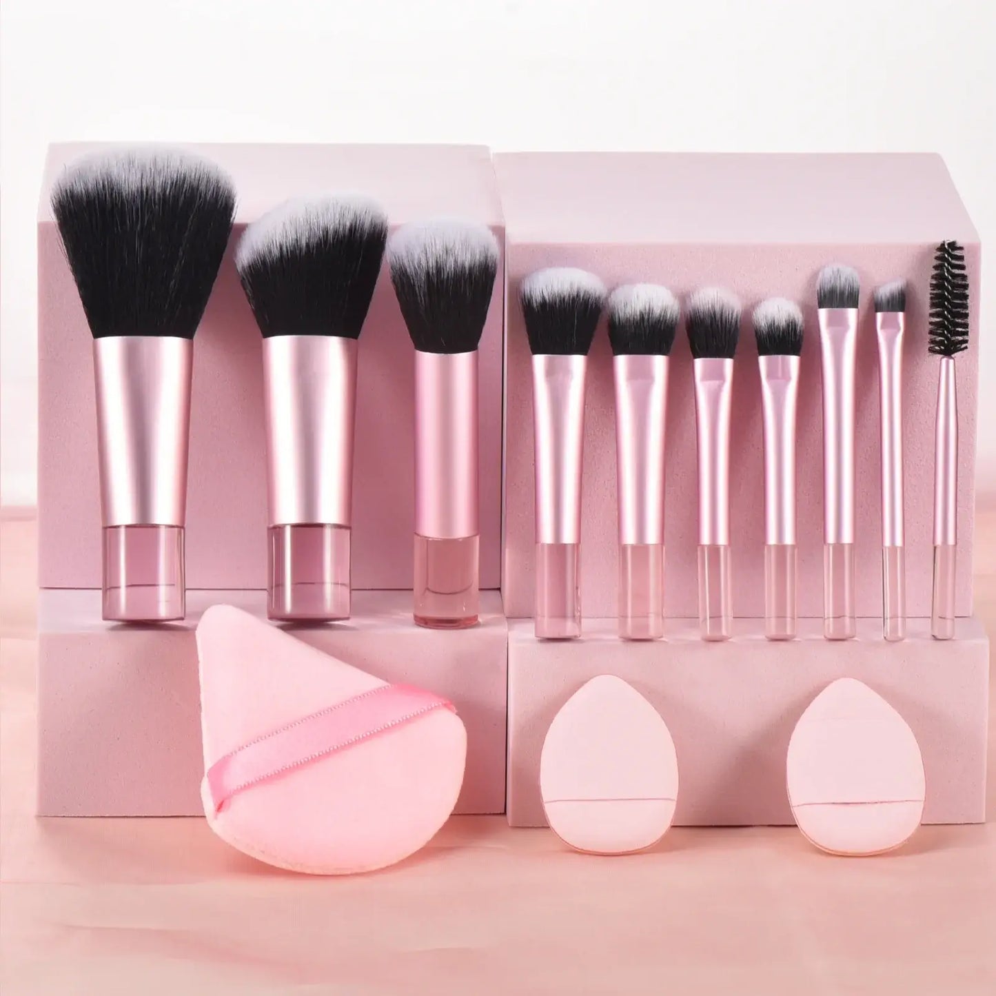 Pink mini travel makeup brushes set with portable palm-sized tools and puffs, ideal for professional makeup application.