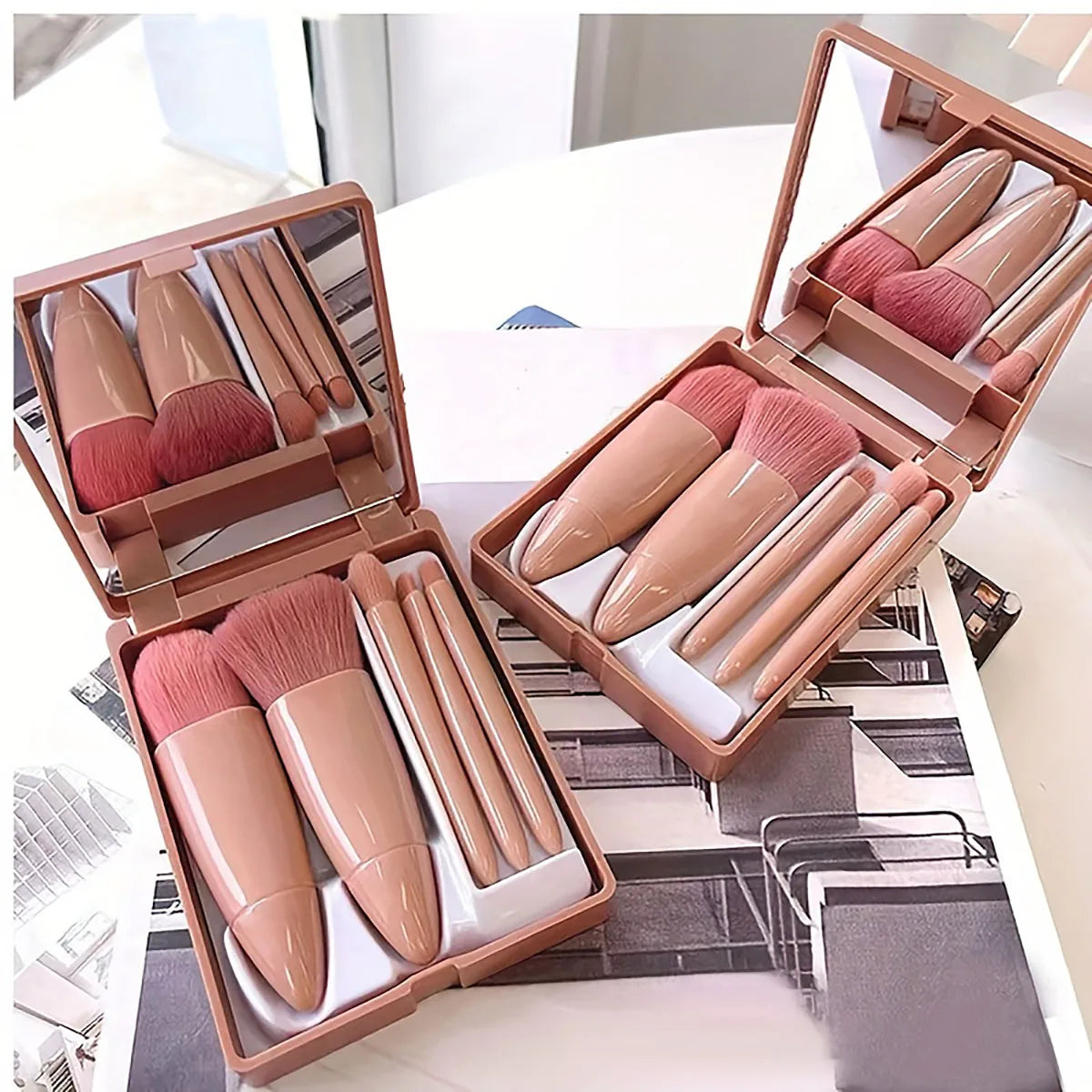 Set of five portable mini makeup brushes with mirror in foldable travel cosmetics kit, ideal for on-the-go beauty routines.