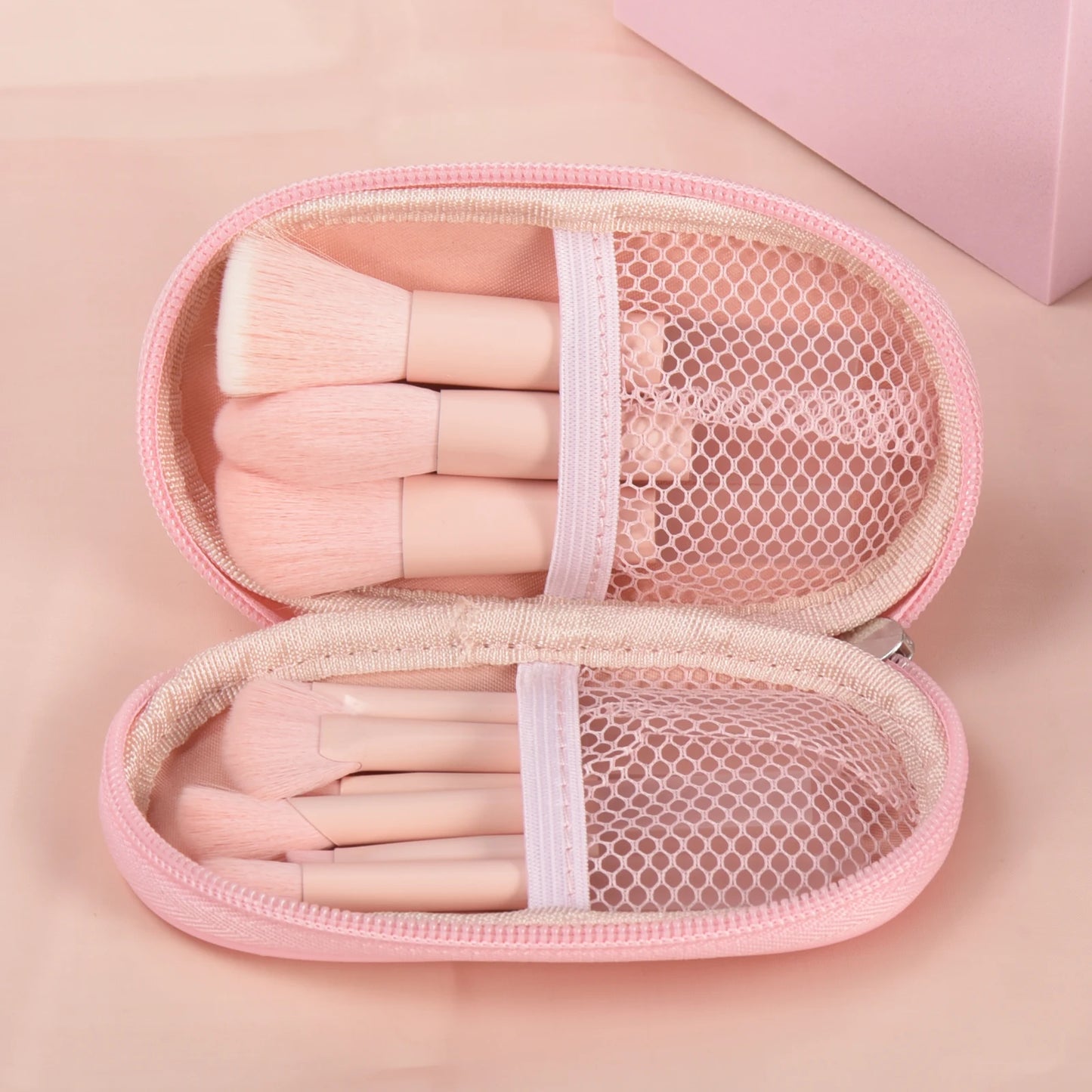 Pink mini travel makeup brush set with palm-sized professional brushes and puffs for portable makeup application by amzzonstore.